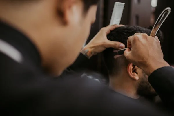 a barber carefully doing the back shave